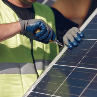 man-with-white-helmet-near-solar-panel